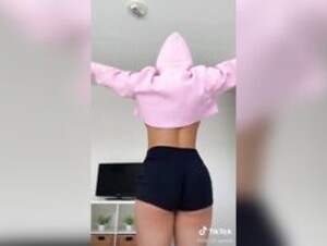 Genna Barton dancing and lifting her cropped hoodie